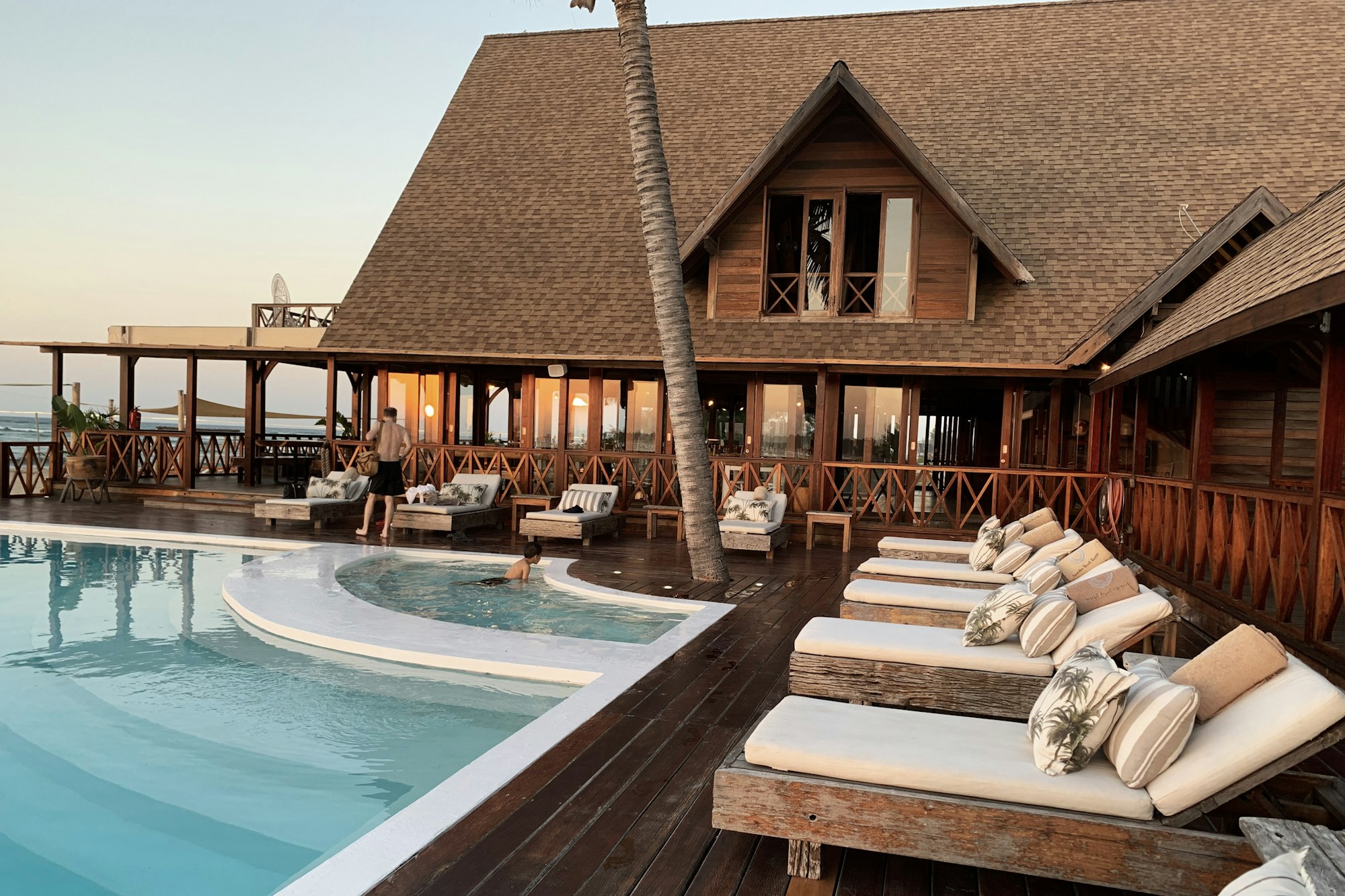 Resort pool and hotel surrounded by tropical greenery